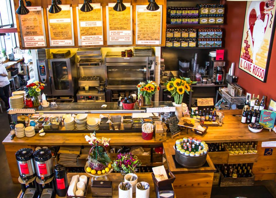 A busy counter for ordering food, with a menu on the wall behind.