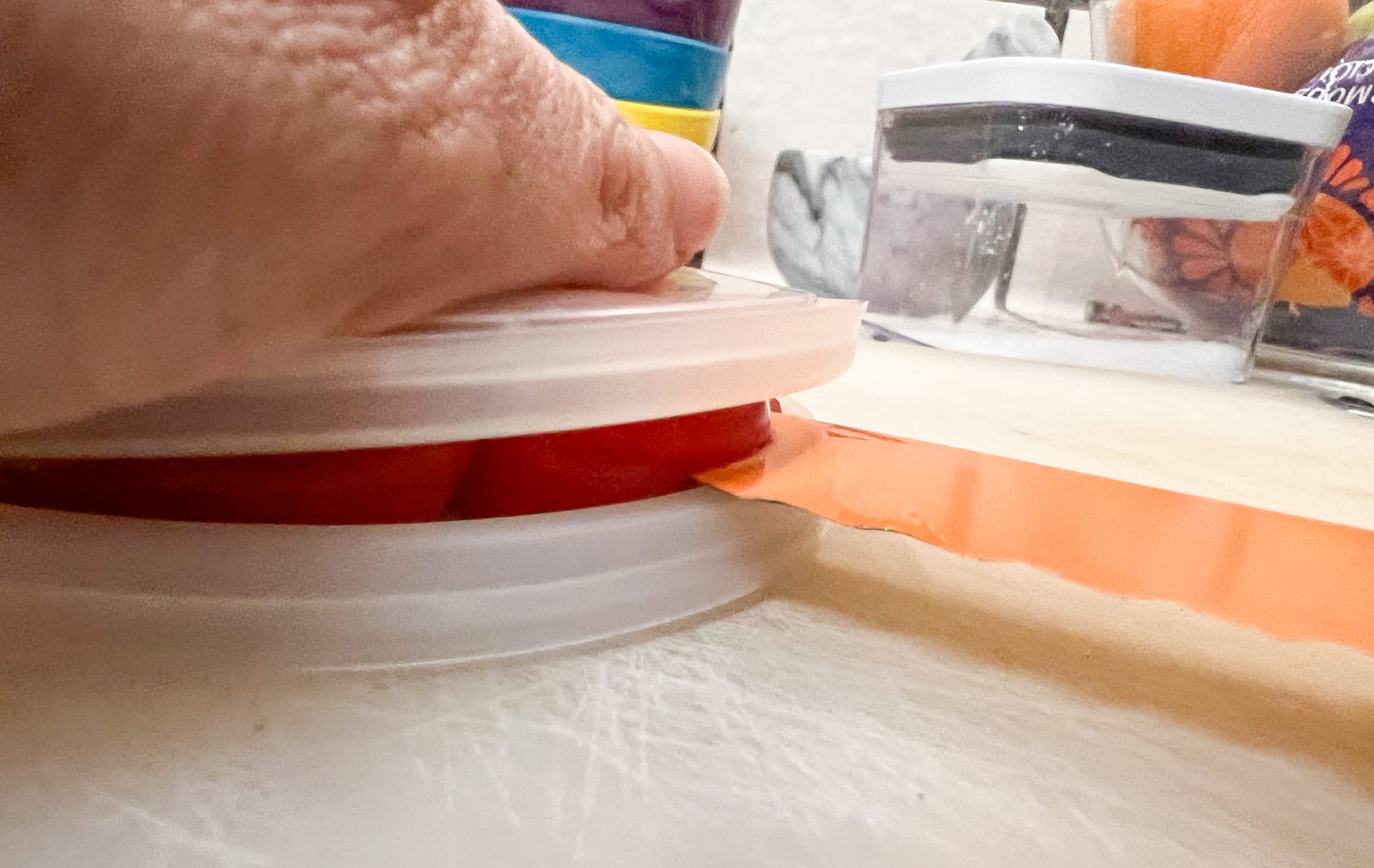 In the side view, you can see the lid-tomatoes-lid sandwich, with the bread knife cutting across the middle, between the lids.