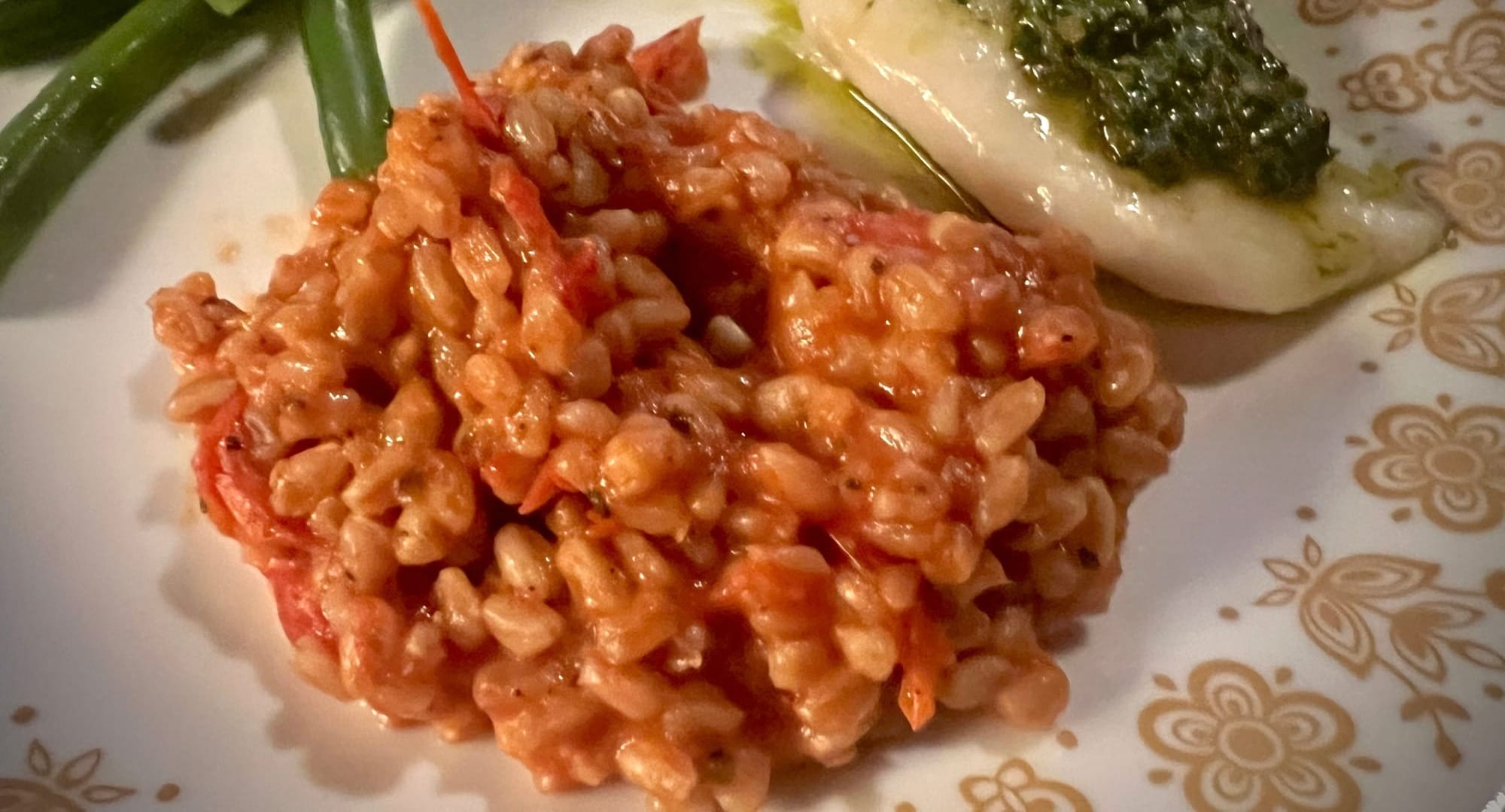 A lumpy mound of farro & tomatoes is on a plate.