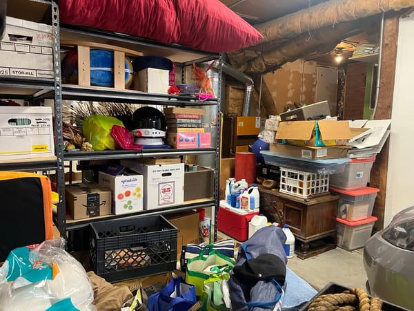 Photo of a garage packed full of random stuff. Some boxes, some furniture.